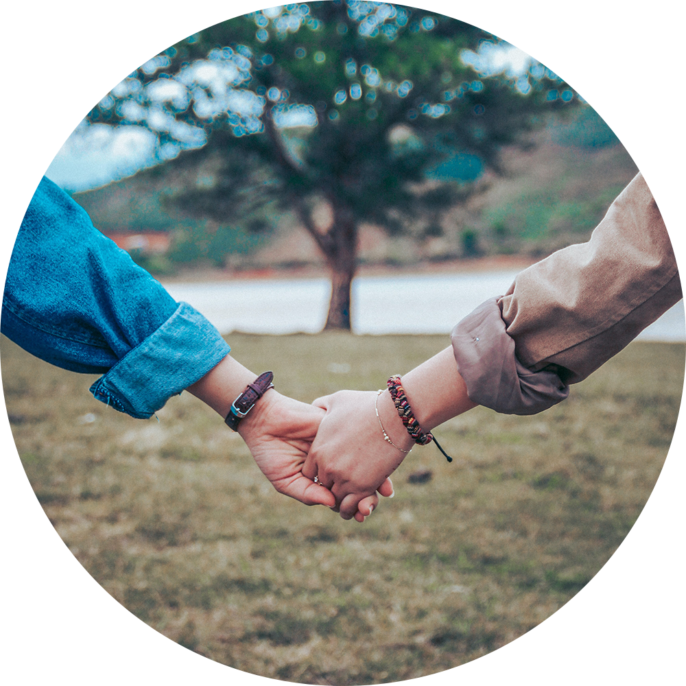 Couple holding hands with tree in the background