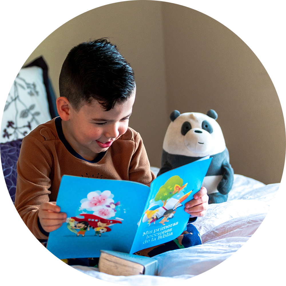 Child happily reading a book on the bed